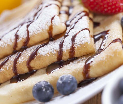Sweet crepes with chocolate drizzle and powdered sugar — Crepes of Paris French breakfast catering, sister kitchen in the Bread and Butter Catering Group